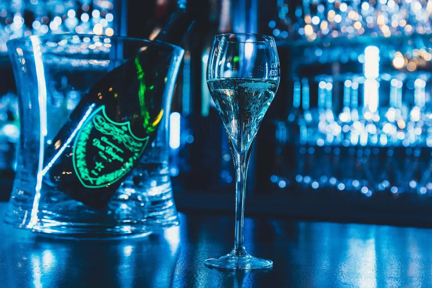 Bouteille et coupe dans la lumière bleue